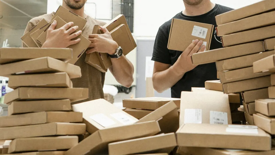 Mitarbeiter verpacken Ware in Versandkartons